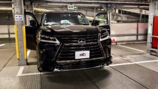 IMG_20260319_190850 – mbFAST Tuning Front view of a shiny black Lexus SUV with both doors open inside an industrial parking garage on a car lift.