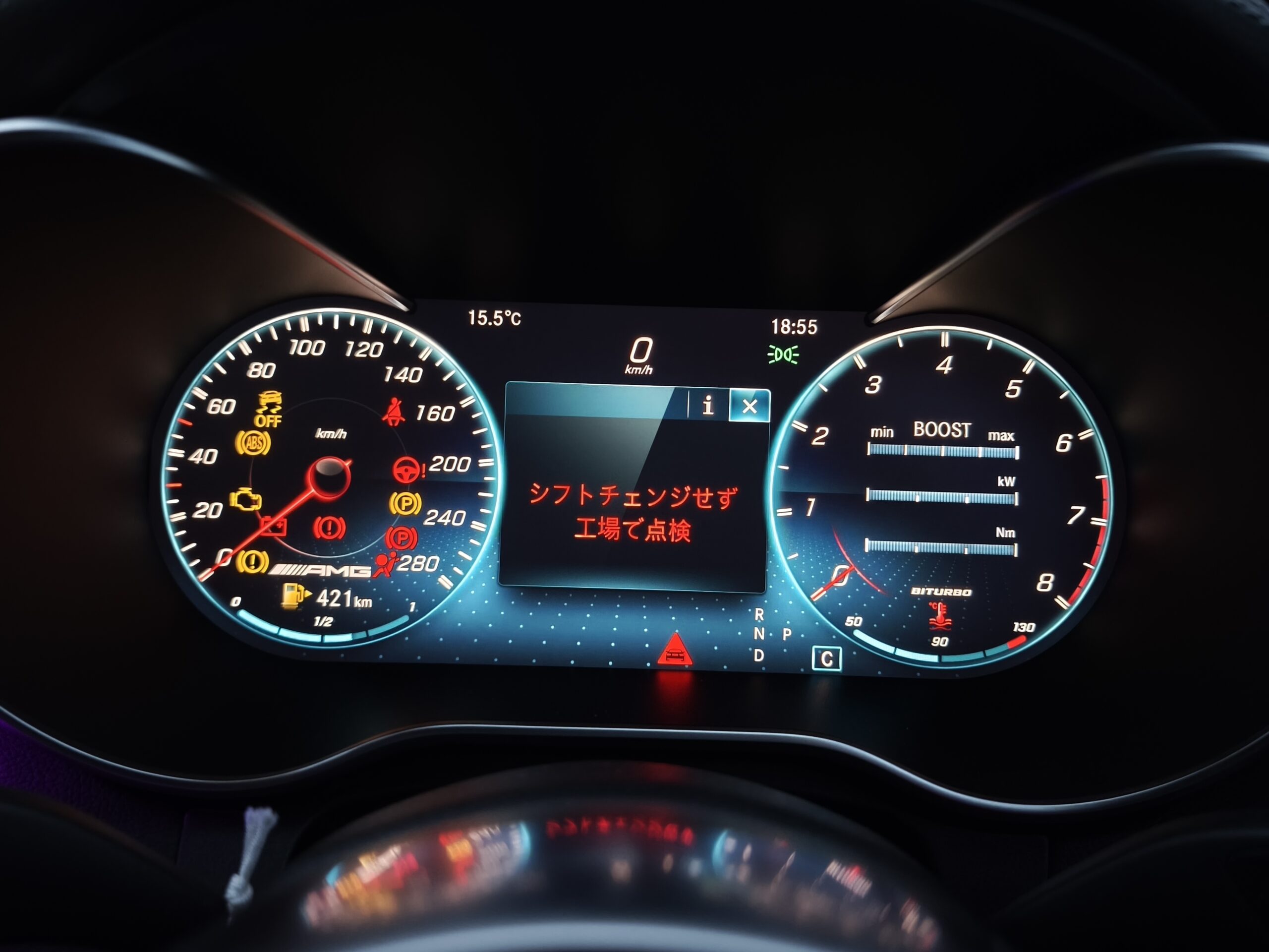 Close-up of a car's illuminated digital instrument cluster with speedometer, tachometer, and warning icons in a dark cabin.