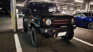 IMG_20251010_224902 – mbFAST Tuning Black off-road SUV parked in a brightly lit indoor parking garage with a blue car nearby in the background.