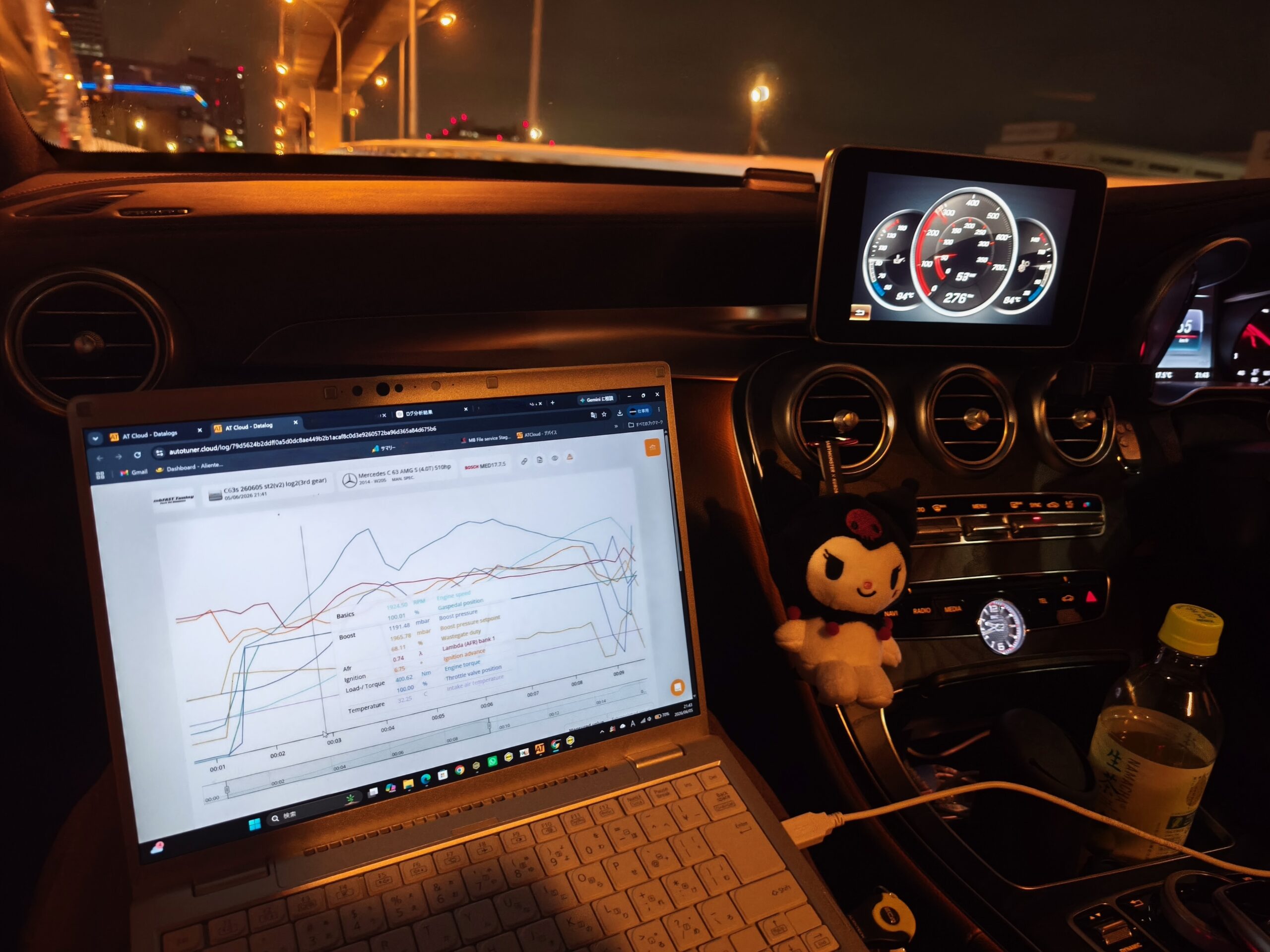 MVIMG_20260605_214359 – mbFAST Tuning Inside a car at night with a laptop on the center console showing multiple line graphs on a white background.