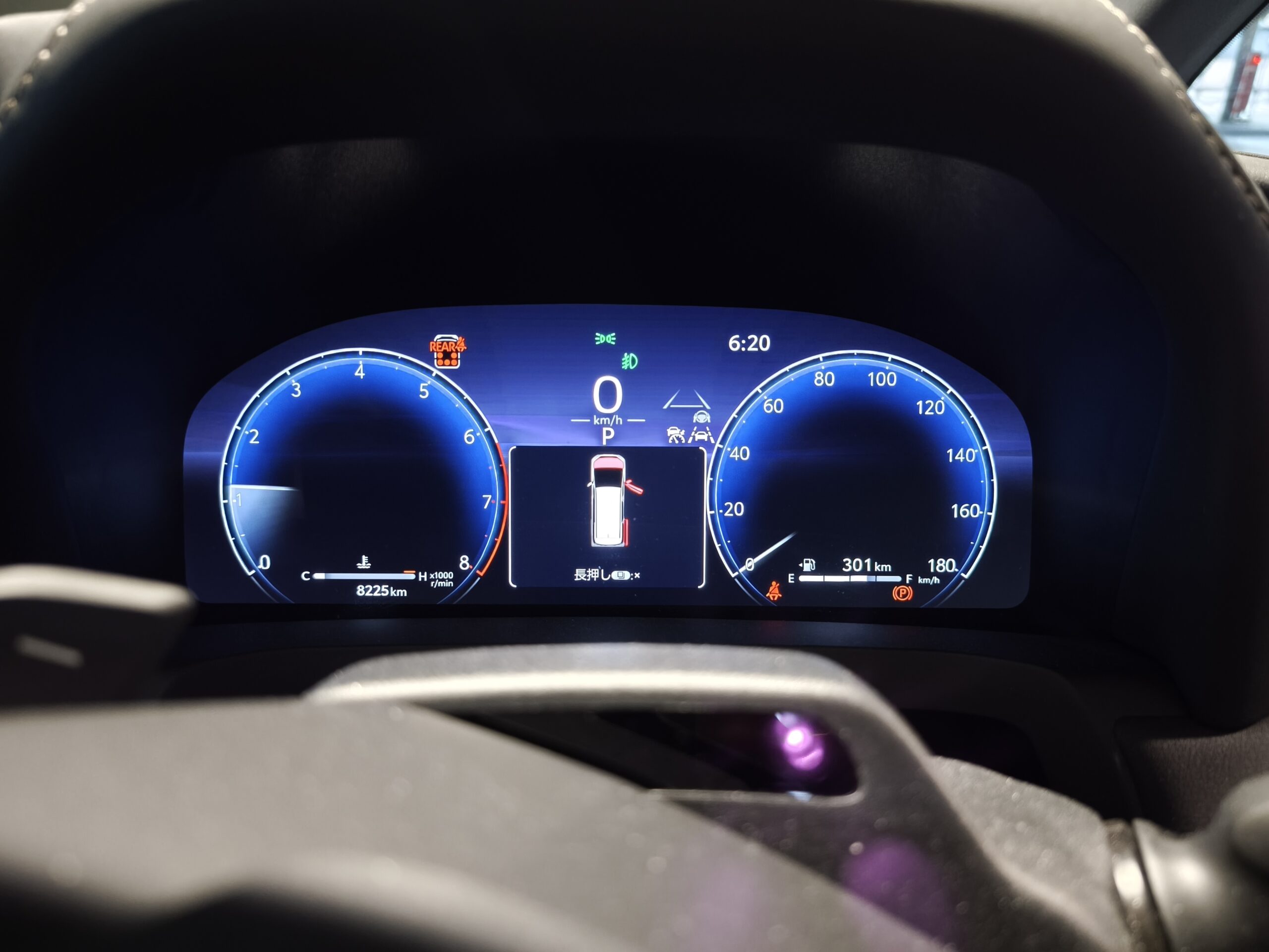 MVIMG_20260608_182037 – mbFAST Tuning Digital car instrument cluster view from behind steering wheel; speedometer at 0 km/h, tachometer and fuel/range indicators visible.