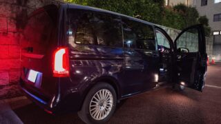 MVIMG_20260608_203847 – mbFAST Tuning Black van parked along a brick wall at night with its side door open, red taillights glowing and wet asphalt visible.