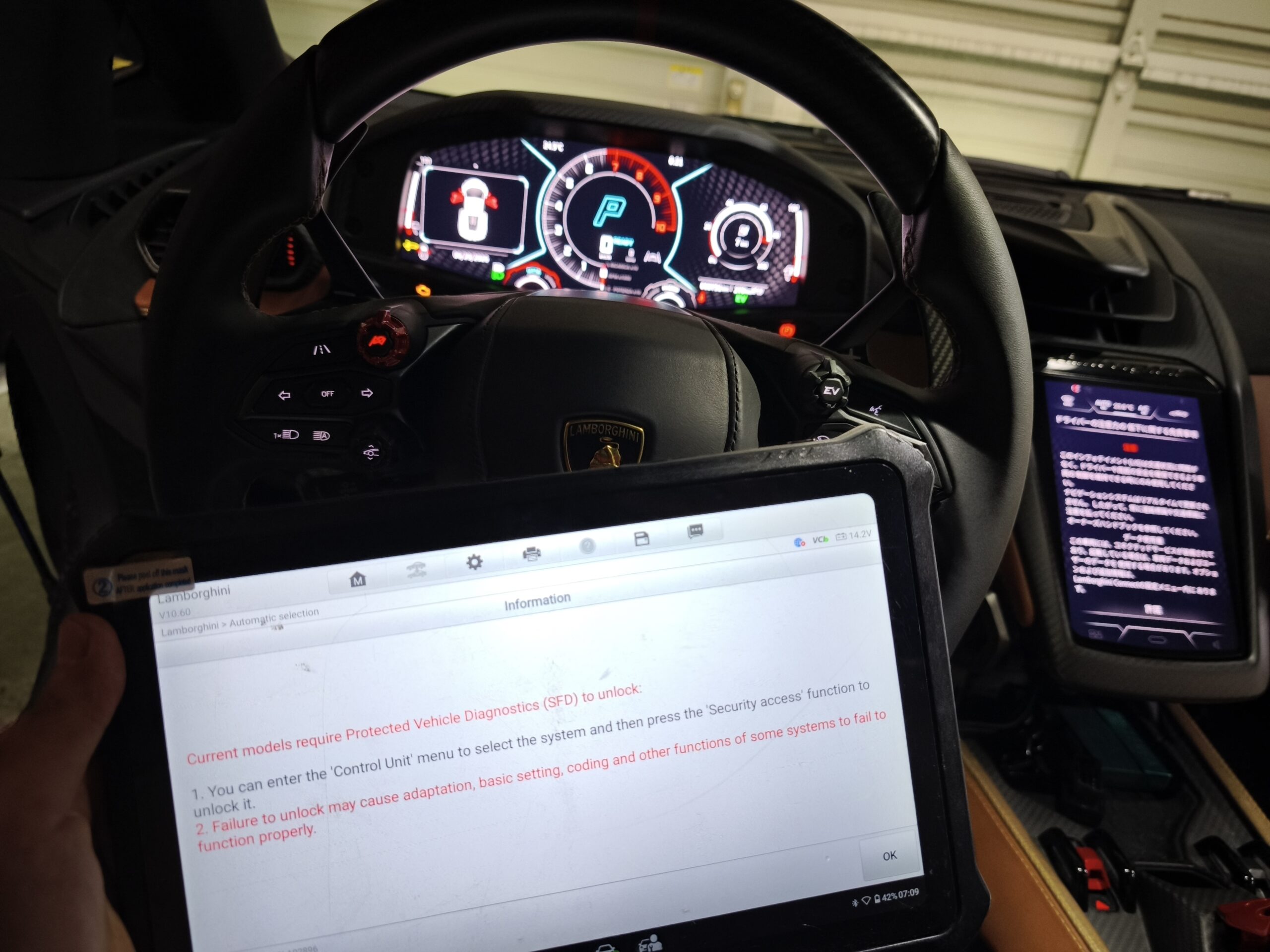 MVIMG_20260620_002115 – mbFAST Tuning Lamborghini cockpit with a digital instrument cluster; a laptop screen in the foreground shows diagnostic text.