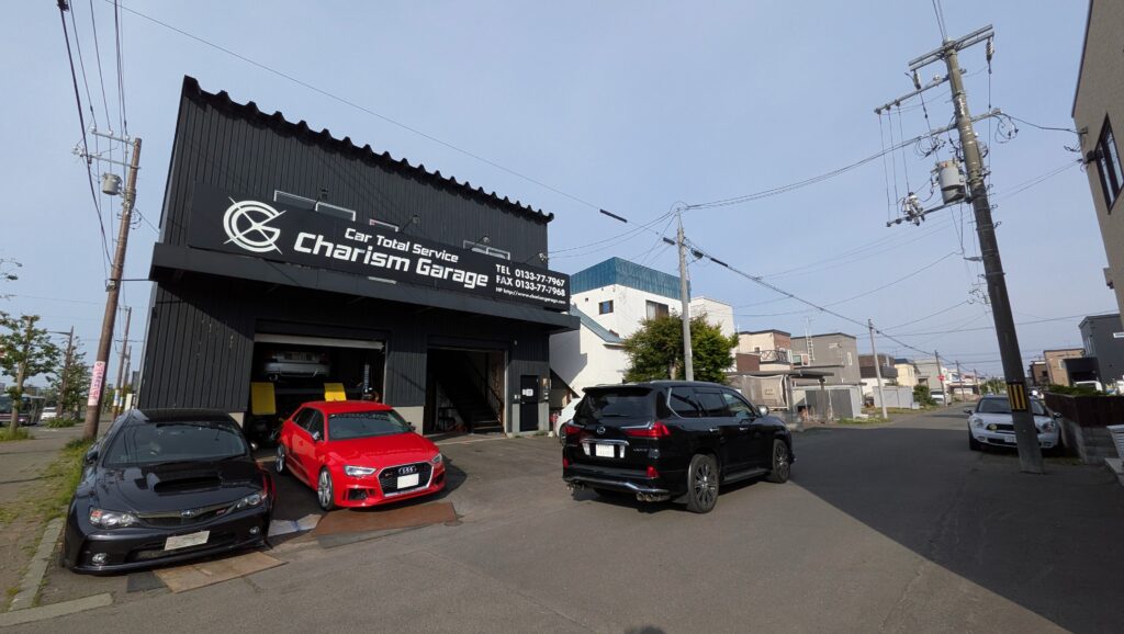 PXL_20260603_073316724 – mbFAST Tuning Auto repair shop exterior with sign 'Charism Garage' and multiple cars parked in front.