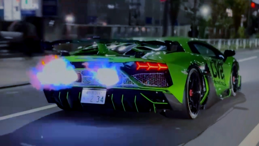 image – mbFAST Tuning Rear view of a bright green high-performance sports car speeding down an urban street, with blue flames erupting from the exhaust and bold neon accents.