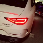 白いCLS53 AMGのリアビュー、テールランプが点灯している様子