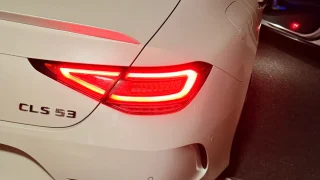 白いCLS53 AMGのリアビュー、テールランプが点灯している様子