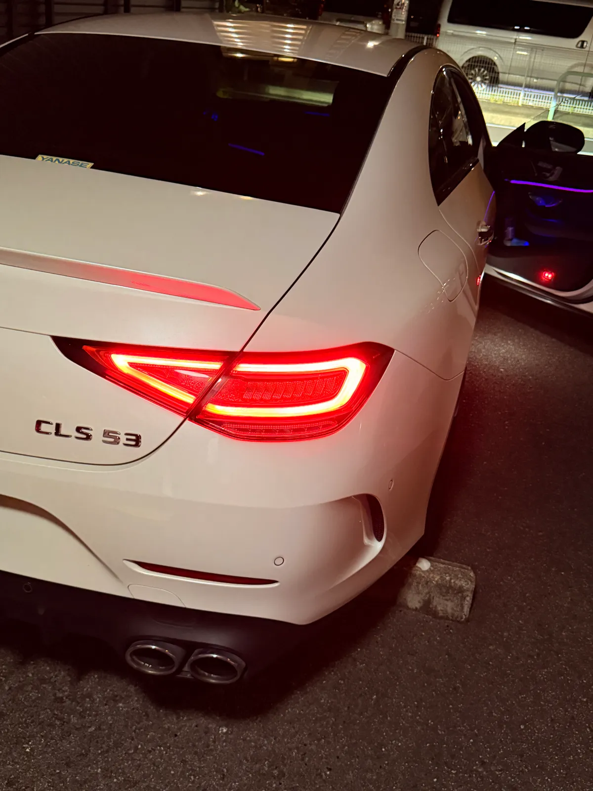白いCLS53 AMGのリアビュー、テールランプが点灯している様子