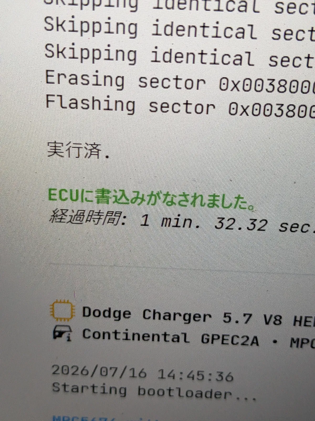 dodge-challenger-57-ecu-tuning-5 – mbFAST Tuning Screen showing a boot log with mixed English/Japanese text; green line reads 'ECUに書込みがなされました。' and elapsed time '経過時間: 1 min. 32.32 sec.' with other boot messages visible below (e.g., 'Starting bootloader').