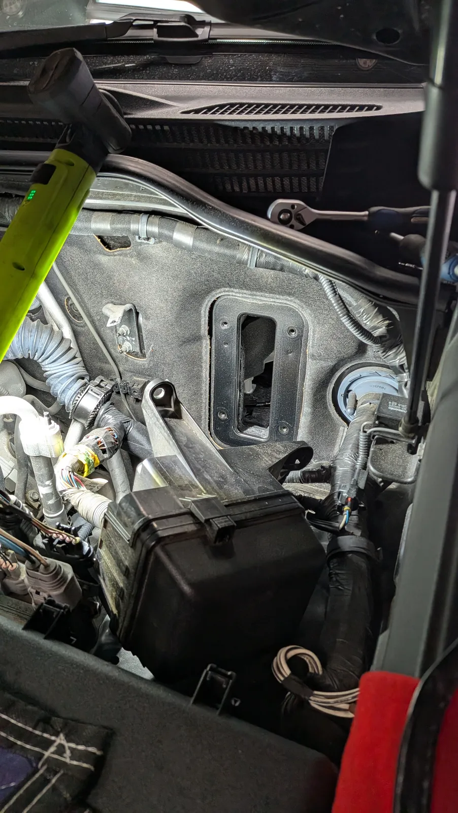 lx570-ecu-tuning-4 – mbFAST Tuning Close-up of a car's interior dash area with exposed wiring, connectors, and a large empty rectangular opening in the dash field of view.