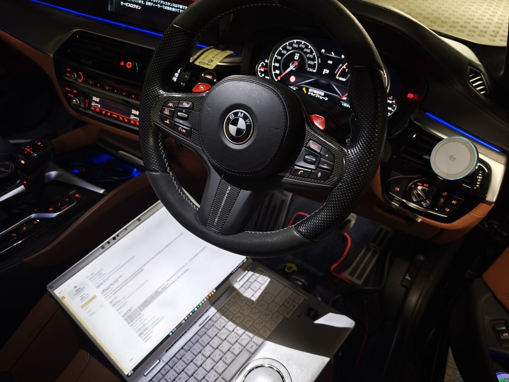 BMW F90 M5 Competitionの車内でセンターコンソールにノートPCを接続しECUチューニングを行う様子