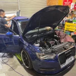 Audi A3のエンジンルームを開けた状態でOBDから接続しECUチューニングを行っている様子
