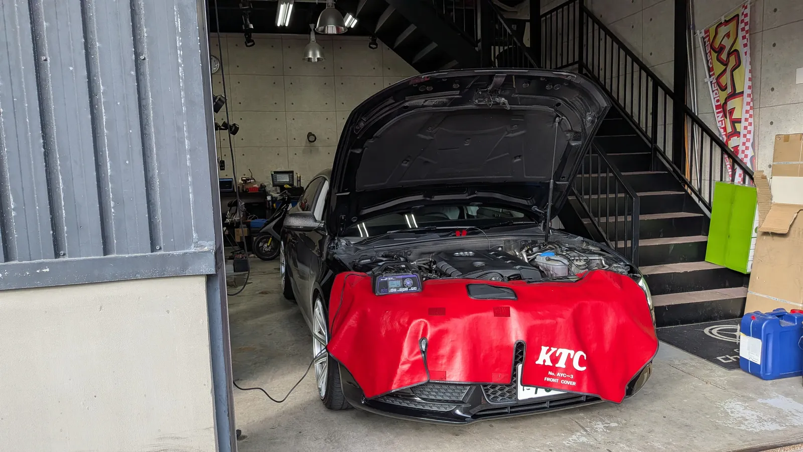 エンジンルームを開けてダイアグ機器を接続しECUチューニング施工中のAudi A5スポーツバック