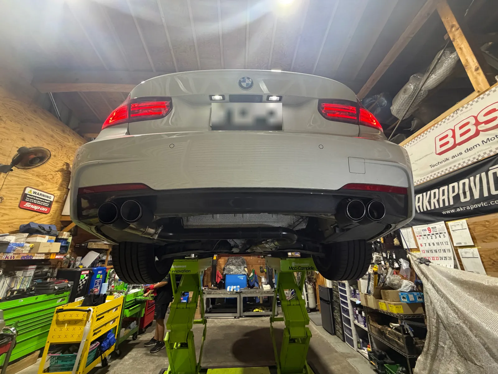 f30-oneoff-muffler-2 – mbFAST Tuning リフトに上げたBMW F30の後方から見たデュアル出しマフラーの様子