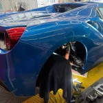 フェラーリ488スパイダーのリアフェンダー内でECU関連作業を行っている様子
