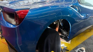 フェラーリ488スパイダーのリアフェンダー内でECU関連作業を行っている様子
