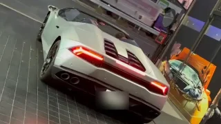White exotic mid-engine sports car seen from the rear, with red tail lights and quad exhausts on a tiled floor.