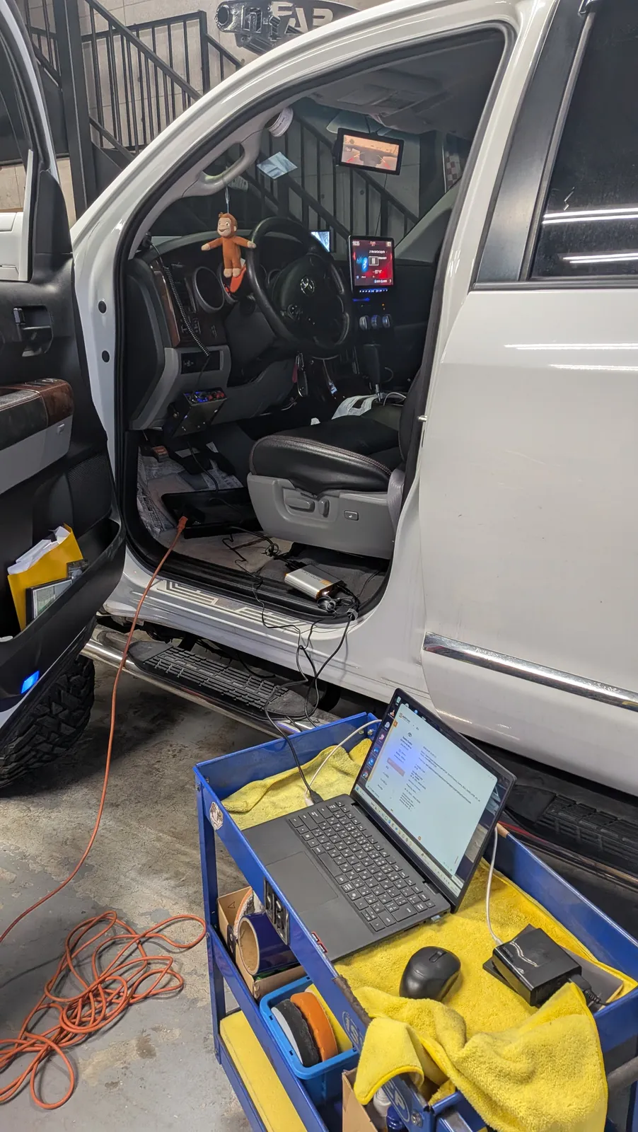 tundra-bubbling-tune-2 – mbFAST Tuning TUNDRAの運転席ドアを開け、ノートパソコンで診断・調整作業を行う様子