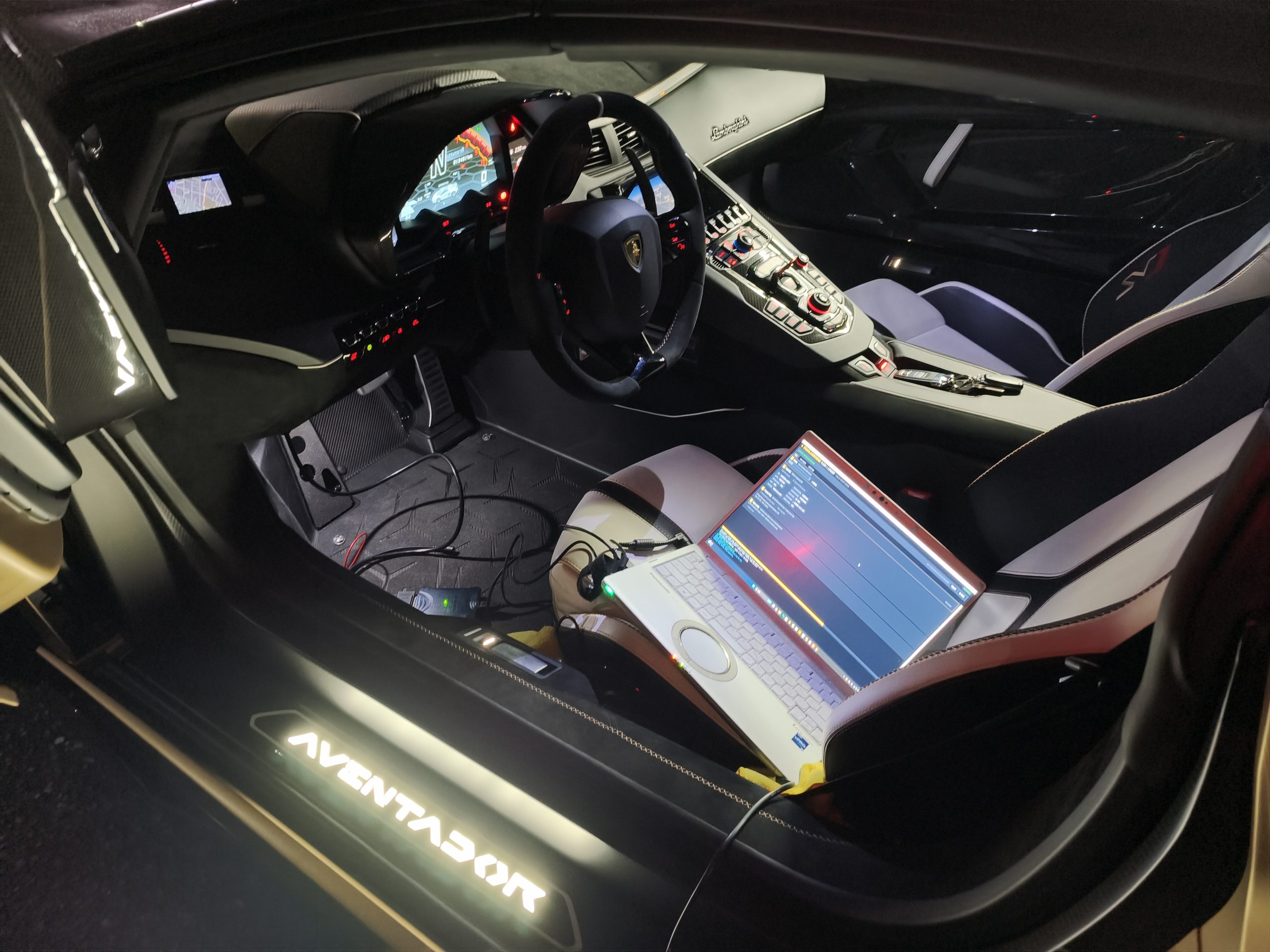 アヴェンタドールの車内、助手席にノートパソコンを置いてOBD接続でECUデータを読み書きする作業の様子