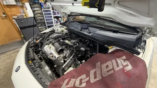 a-class176-thermostat-replacement-1 – mbFAST Tuning Aクラスのエンジンルームを開けてサーモスタット交換作業を行っている様子
