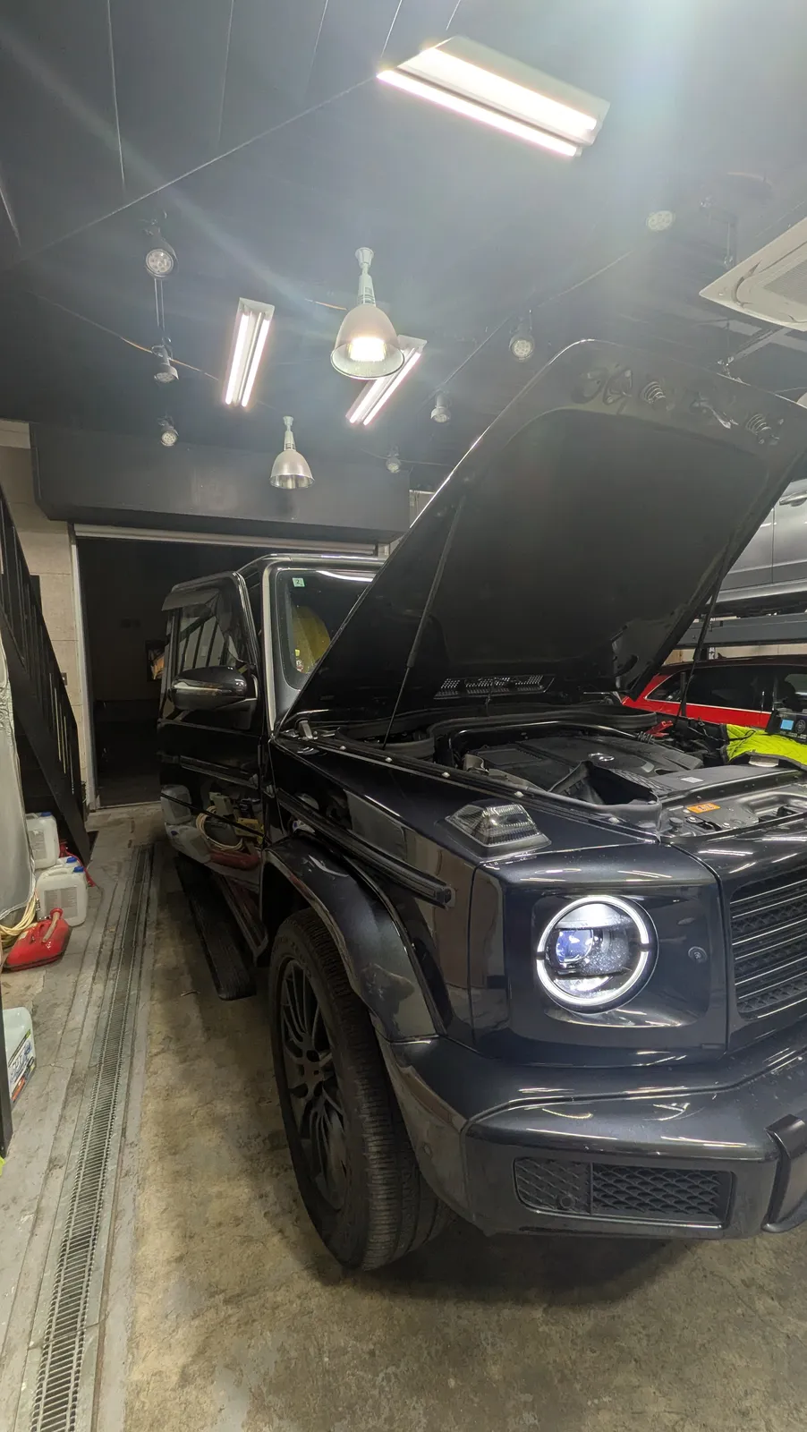 g350d-diesel-tuning-1 – mbFAST Tuning Black Mercedes-Benz G-Class SUV in a workshop with the hood raised, engine visible.