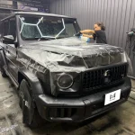 マット塗装のW465 G63 AMGのボンネットに施工者が保護フィルムを施しながら拭き上げている様子