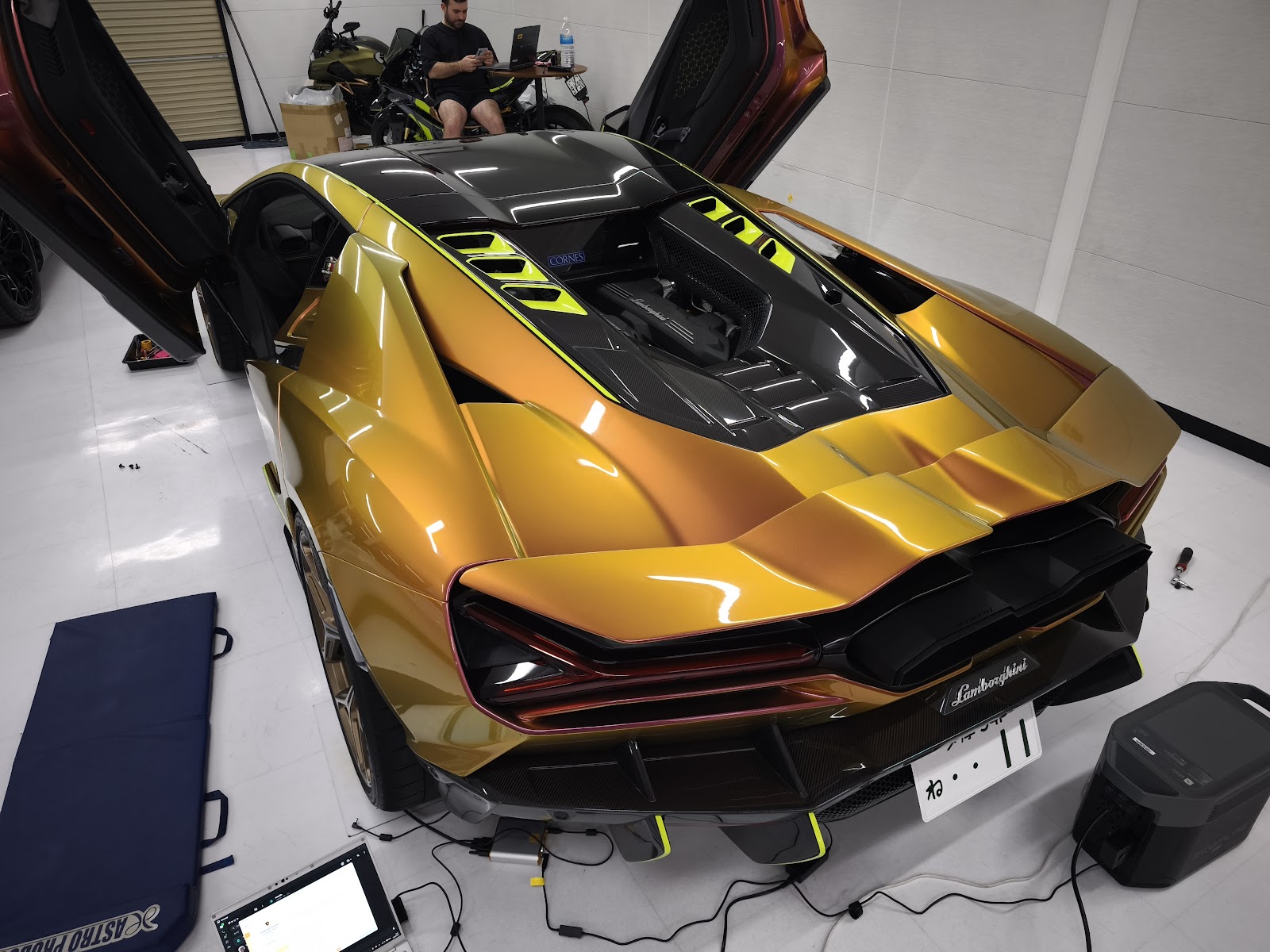 Rear view of a Maziora Lamborghini Revuelto from above, V12 – mbFAST Tuning Rear view of a Maziora Lamborghini Revuelto from above, V12 engine cover exposed, laptop and cables connected for the Flames calibration