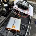 MINIのECUを取り外し専用ツールで書き換え作業を行っている様子