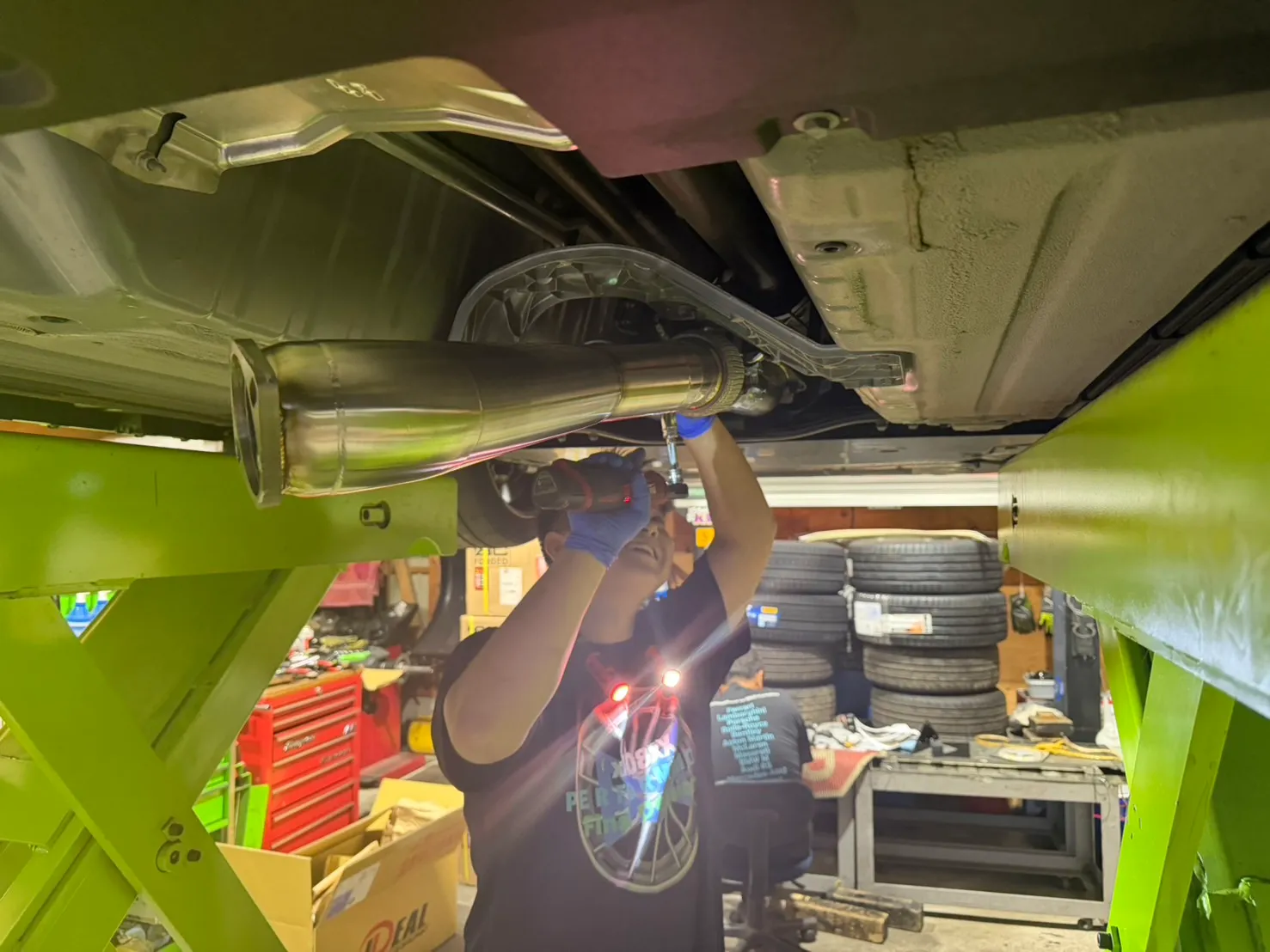 gtr-exhaust-airsuspension-2 – mbFAST Tuning 車両下部でマフラーを取り付ける作業の様子