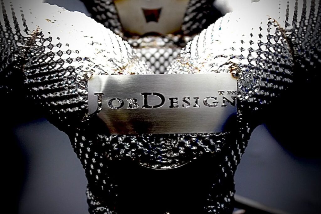 Metallic name plate reading'JonDesign' held by gloved hands within sparkly gloves.