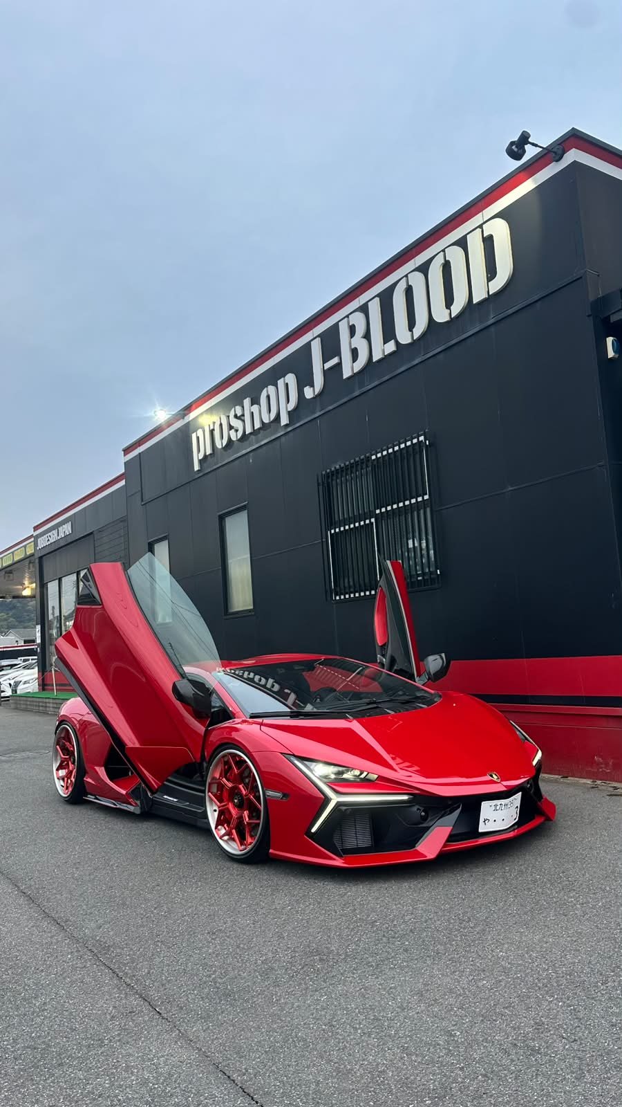 北九州市小倉南区のJobDesign（proshop J-BLOOD）店舗前でドアを開けた赤いランボルギーニ・レヴェルト